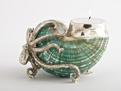 an octopus candle holder sitting on top of a green shell