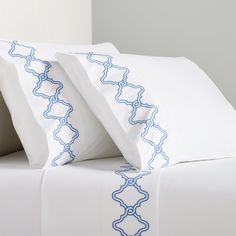 two white pillows sitting next to each other on a bed