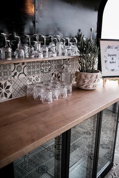 a wooden table topped with lots of glasses