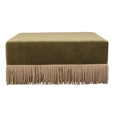 a green ottoman with fringes on it