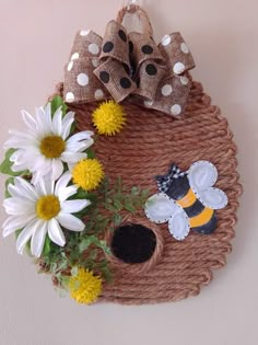 a basket filled with flowers and bees on top of a wall next to a bow