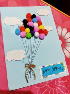 a birthday card with pom - poms attached to the back of a balloon