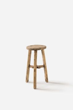 a small wooden stool sitting on top of a white floor