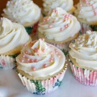 several cupcakes with white frosting and sprinkles