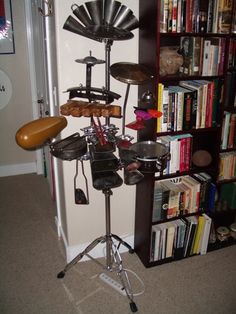 there is a drum set in front of the bookshelf