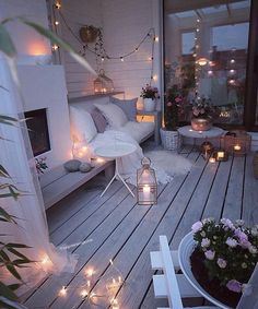 an outdoor deck is lit with candles and flowers