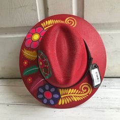 Stay stylish in this beautiful colorful hand painted straw hat, ideal for any sunny day occasion. Every single hat is hand painted uniquely which means there will never be another one like it. MADE IN MEXICO By: Mexican Artisans For: Women Size: Large (23.5") Color: red | multi Details: Material: Palm Straw Leather Band Inner elastic band Contact us for more details PLEASE READ BEFORE PURCHASE: The picture is an ACCURATE REPRESENTATION. Colors in the pictures may vary a little by effects of ligh Painted Hats, Homemade Crafts, Shoes With Jeans, Sunny Day, Another One, Art Paint, Straw Hat, Leather Band, Elastic Band