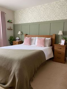 there is a large bed with pink pillows and blankets on the headboard in this bedroom