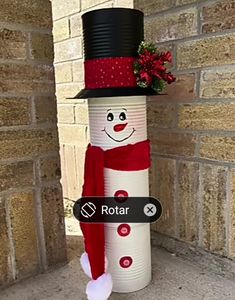 a snowman made out of cans with a top hat and scarf around it's neck