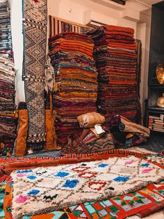 a room filled with lots of colorful carpets and rugs on the floor next to each other