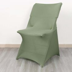 a green chair sitting on top of a hard wood floor next to a white wall