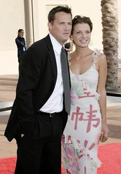 a man and woman standing on a red carpet