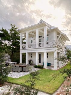 a large white house sitting on top of a lush green field