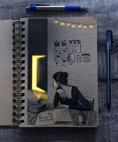 an open notebook with a drawing of a woman reading