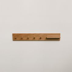 a wooden coat rack with five pegs on it