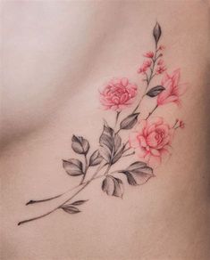 a woman's stomach with pink flowers and leaves on the side, tattoo style