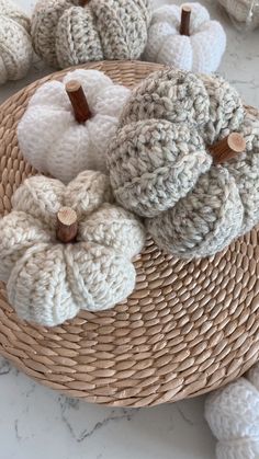 crocheted pumpkins are sitting on a woven basket