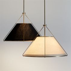 two lamps hanging from the ceiling, one with a black shade on it and one without