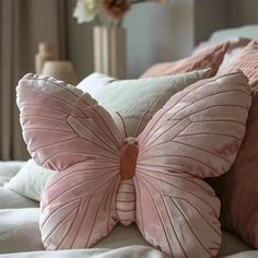 a pink butterfly pillow sitting on top of a bed