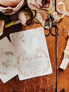 wedding stationery with flowers and scissors on wooden table