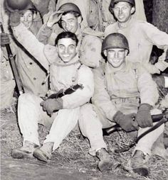 black and white photograph of men in uniforms posing for a group photo with baseball bats