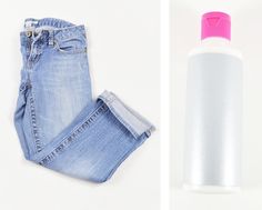 a pair of light blue jeans and a white bottle with pink cap sitting next to each other