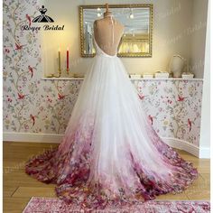 a wedding dress on display in front of a wallpapered room with a mirror