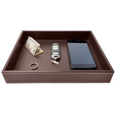 a cell phone and keys in a brown leather tray with keychain on it