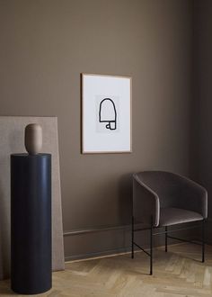 two chairs and a vase in a room with a wall hanging on the wall behind them