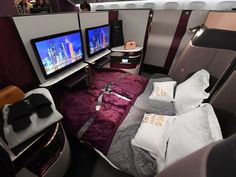 the inside of an airplane with two televisions on each side and pillows on the floor