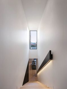 there is a stair leading up to the second floor in this modern house with white walls and wood floors