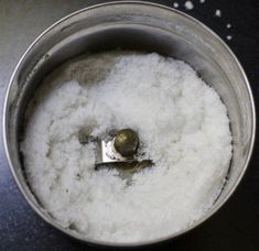 a metal bowl filled with white powder on top of a table