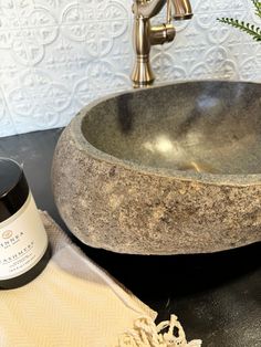 a granite sink with a bottle of wine next to it on a black countertop