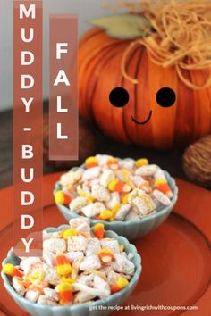 two blue bowls filled with candy corn on top of an orange plate