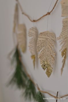 some type of paper hanging from a tree branch with leaves and branches attached to it