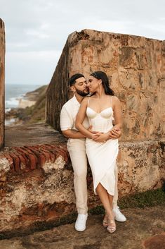 Chris is sitting on a ledge of a Spanish fort, Nicole is sitting on his lap, faces looking at each other almost kissing. Old San Juan Engagement Photos, Cartagena Photoshoot, Photographs Idea, Cruise Poses, Engagement Photo Shoot Outfits, Spanish Style Wedding, Engagement Picture Outfits, Fun Engagement Photos