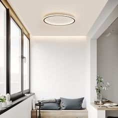 a white room with a window seat and some plants on the windowsill, along with other furniture