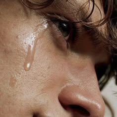 a close up of a woman's face with drops of water on her cheek