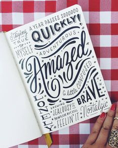 a notebook with hand lettering on it sitting next to a red and white checkered table cloth