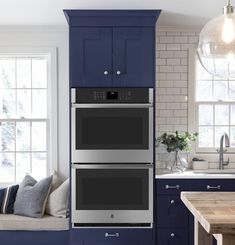 a kitchen with blue cabinets and two double ovens in front of a counter top