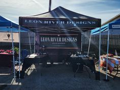 a tent set up with tables and chairs under it for an open air design event