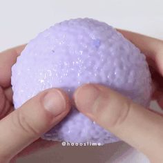 a person holding a purple ball in their hand