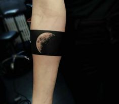 a man with a half moon tattoo on his arm