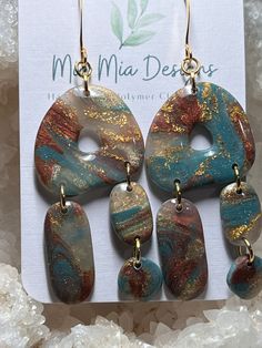 These adorable abstract earrings are handcrafted using translucent polymer colored with blue, rust with added gold leafing to create a one-of-a-kind pair of earrings.  Assembled using gold embellishments, these earrings are both lightweight and hypoallergenic. Bohemian Gold Resin Earrings, Unique Resin Dangle Earrings, Unique Dangle Resin Earrings, Artsy Blue Dangle Earrings, Handmade Turquoise Resin Earrings, Artsy Resin Earrings With Ear Wire, Artsy Resin Dangle Earrings, Turquoise Dangle Earrings In Resin, Artsy Resin Drop Earrings