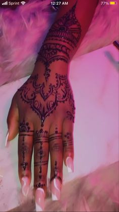 a woman's hand with henna tattoos on it