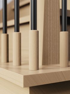 three black poles sticking out of the side of a wooden shelf