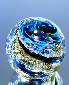 a glass ball sitting on top of a metal stand with water droplets all over it