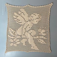 a crocheted pillow is hanging on the wall next to a blue painted wall