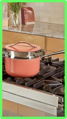 an orange pot sitting on top of a stove