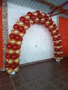 an arch made out of balloons in the middle of a room with tile flooring